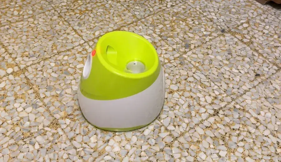 The lime-green launcher on gravel, outdoors